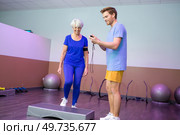 coach timing the elderly woman on doing the stepper. Стоковое фото, агентство Ingram Publishing / Фотобанк Лори
