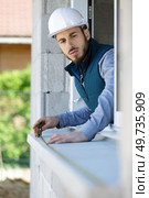 man measuring window prior to installation of roller shutter outdoors. Стоковое фото, агентство Ingram Publishing / Фотобанк Лори