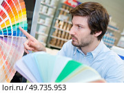 man pointing at his preferred shade of blue. Стоковое фото, агентство Ingram Publishing / Фотобанк Лори