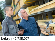 Men looking at wood in materials outlet. Стоковое фото, агентство Ingram Publishing / Фотобанк Лори