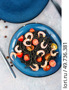 Vegetarian black spaghetti or pasta with prawn and tomatoes. Healthy food concept.. Vegan spaghetti, pasta with shrimp. Стоковое фото, агентство Ingram Publishing / Фотобанк Лори