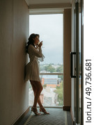 brown-haired girl in the morning in a bathrobe in the hotel corridor with a glass of white wine. Стоковое фото, агентство Ingram Publishing / Фотобанк Лори
