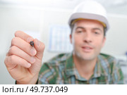 Builder holding up a pen. Стоковое фото, агентство Ingram Publishing / Фотобанк Лори