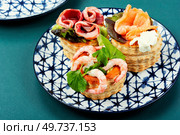 Appetizing tartlets with fish, shrimp and bacon. Festive table. Concept of food, restaurant.. Tartlets, canapes with smoked salmon, shrimp and bacon. Стоковое фото, агентство Ingram Publishing / Фотобанк Лори