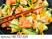 Asian spicy salad with salted salmon and fresh cucumbers and chopstick. Low carbohydrate breakfast.. Fish salad with cucumber, macro. Стоковое фото, агентство Ingram Publishing / Фотобанк Лори