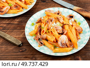 Appetizing macaroni or pasta boiled with octopus. Pasta with seafood on old rustic wooden table.. Macaroni with tentacles of octopus. Стоковое фото, агентство Ingram Publishing / Фотобанк Лори