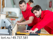 carpenter showing apprentice how to use machine. Стоковое фото, агентство Ingram Publishing / Фотобанк Лори