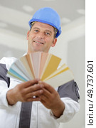 handyman showing fanned color swatches over white background. Стоковое фото, агентство Ingram Publishing / Фотобанк Лори