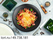 Pasta with roasted bacon served on a black plate, pasta carbonara. Italian pasta dish. Top view.. Italian classic pasta carbonara. Стоковое фото, агентство Ingram Publishing / Фотобанк Лори