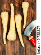Raw and uncooked parsnips roots on old rustic wooden table. Fresh vegetable.. Raw parsnip roots on wooden table. Стоковое фото, агентство Ingram Publishing / Фотобанк Лори