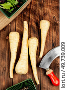 Raw and uncooked parsnips roots on old rustic wooden table. Fresh vegetable.. Raw parsnip roots on wooden table. Стоковое фото, агентство Ingram Publishing / Фотобанк Лори