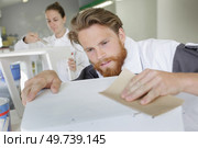 home improvement worker smoothing surface. Стоковое фото, агентство Ingram Publishing / Фотобанк Лори