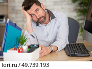 despondent male office worker has possessions packed in a box. Стоковое фото, агентство Ingram Publishing / Фотобанк Лори