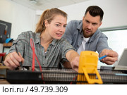 man and woman holding digital multimeter. Стоковое фото, агентство Ingram Publishing / Фотобанк Лори