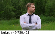 Confident Businessman in Natural Setting. Man stands in front of lush green backdrop. Remote working. Portrait of happy mid adult male wearing formal clothes, shirt and tie, glasses. Find inspiration. Стоковое видео, видеограф Марина Демидюк / Фотобанк Лори