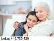 a grandmother is cuddling granddaughter. Стоковое фото, агентство Ingram Publishing / Фотобанк Лори