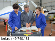 people reading the aircrafts manual. Стоковое фото, агентство Ingram Publishing / Фотобанк Лори