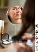 happy woman cleaning face in bathroom mirror. Стоковое фото, агентство Ingram Publishing / Фотобанк Лори
