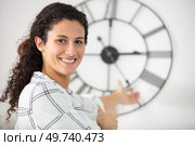 young brunette woman posing with wall clock. Стоковое фото, агентство Ingram Publishing / Фотобанк Лори