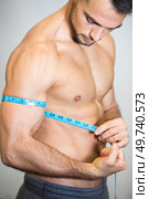 strong guy is feeling delighted while estimating his muscle size. Стоковое фото, агентство Ingram Publishing / Фотобанк Лори
