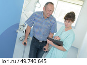 nurse with mature man on crutches. Стоковое фото, агентство Ingram Publishing / Фотобанк Лори