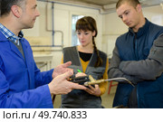 ironworks teacher showing students how to securely use gas welder. Стоковое фото, агентство Ingram Publishing / Фотобанк Лори