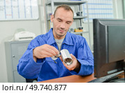 male worker checking a security camera. Стоковое фото, агентство Ingram Publishing / Фотобанк Лори