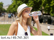 woman drinking water from plastic bottle on sunny day. Стоковое фото, агентство Ingram Publishing / Фотобанк Лори