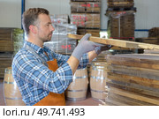 a male worker checking the wood delivery. Стоковое фото, агентство Ingram Publishing / Фотобанк Лори