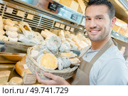 Man displaying cheeses in basket. Стоковое фото, агентство Ingram Publishing / Фотобанк Лори