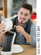 professional young repairman fixing coffee machine. Стоковое фото, агентство Ingram Publishing / Фотобанк Лори