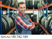 happy male worker checking tyres in a garage. Стоковое фото, агентство Ingram Publishing / Фотобанк Лори