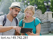 young couple using tablet my landmark fountain. Стоковое фото, агентство Ingram Publishing / Фотобанк Лори