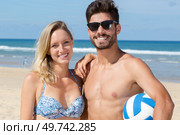 happy active man and woman playing volleyball on beach together. Стоковое фото, агентство Ingram Publishing / Фотобанк Лори