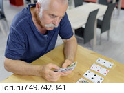 portrait of a man playing cards. Стоковое фото, агентство Ingram Publishing / Фотобанк Лори