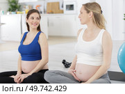 young pregnant women doing relaxation exercise on exercising mat. Стоковое фото, агентство Ingram Publishing / Фотобанк Лори