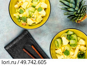 Healthy vegetarian salad with pineapple or ananas, nuts and cucumber in a bowl. Top view.. Fresh vegan salad with pineapple. Стоковое фото, агентство Ingram Publishing / Фотобанк Лори