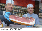Man holding cured ham. Стоковое фото, агентство Ingram Publishing / Фотобанк Лори