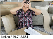 Exasperated woman trying to assemble furniture. Стоковое фото, агентство Ingram Publishing / Фотобанк Лори