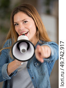 young woman with megaphone pointing at viewer. Стоковое фото, агентство Ingram Publishing / Фотобанк Лори