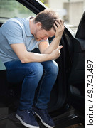 troubled man sat in his car with the door open. Стоковое фото, агентство Ingram Publishing / Фотобанк Лори