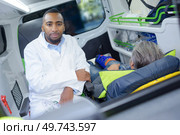 male doctor taking pulse of a man inside ambulance. Стоковое фото, агентство Ingram Publishing / Фотобанк Лори