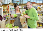 shop assistant serving chayote to customer. Стоковое фото, агентство Ingram Publishing / Фотобанк Лори