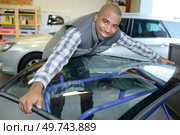 a man is carrying windshield. Стоковое фото, агентство Ingram Publishing / Фотобанк Лори