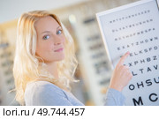 Lady pointing at eye test chart. Стоковое фото, агентство Ingram Publishing / Фотобанк Лори