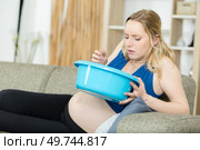 pregnant woman holding bowl ready to vomit. Стоковое фото, агентство Ingram Publishing / Фотобанк Лори