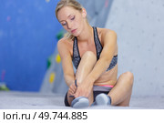 woman strapping her wall climbing shoes. Стоковое фото, агентство Ingram Publishing / Фотобанк Лори