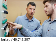 two men working on a machine. Стоковое фото, агентство Ingram Publishing / Фотобанк Лори