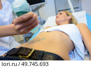 doctor doing an ultrasound of a patient abdomen. Стоковое фото, агентство Ingram Publishing / Фотобанк Лори