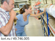 Woman and man in hardware store, choosing from racking. Стоковое фото, агентство Ingram Publishing / Фотобанк Лори